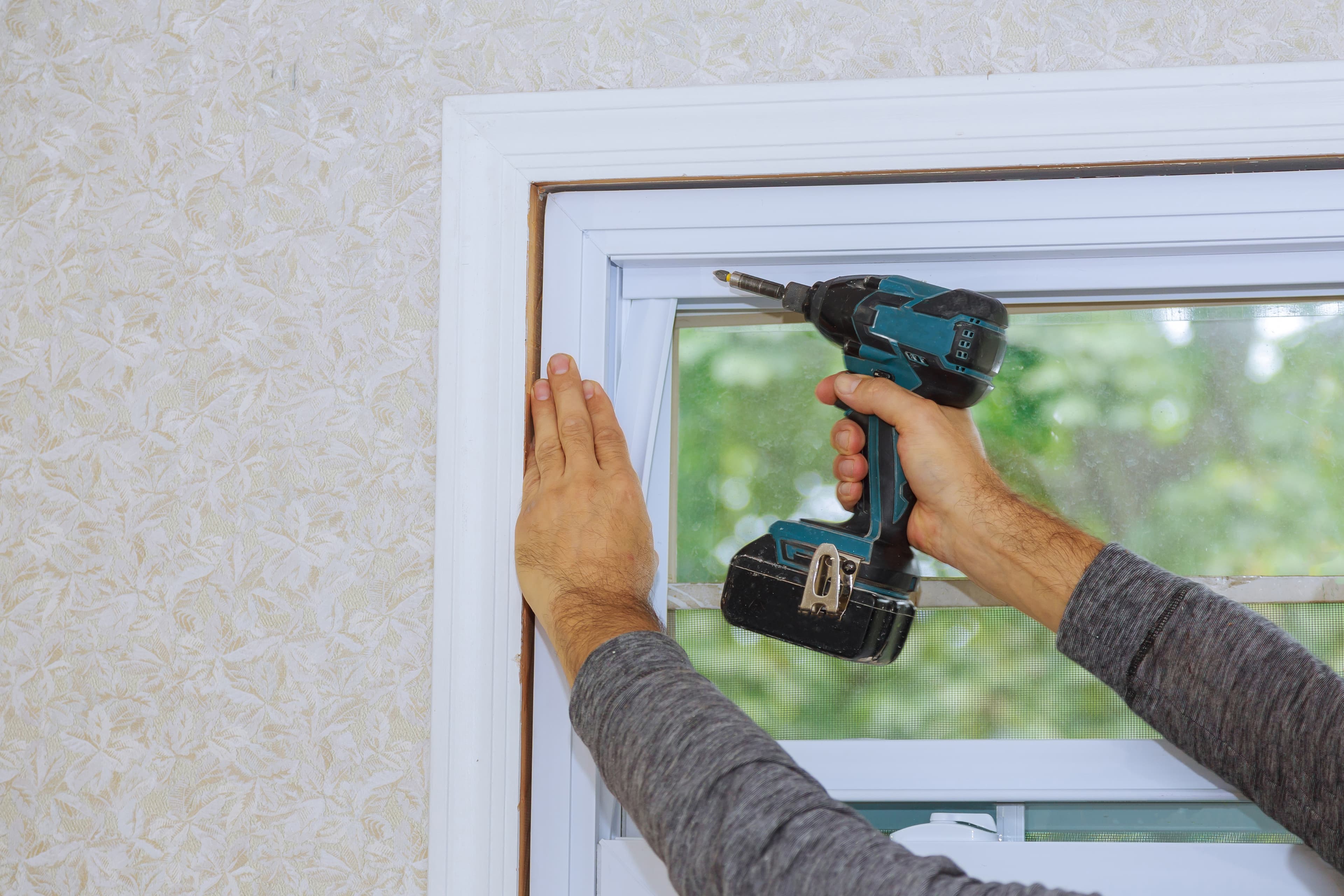 A person repairing a window screen with a drill at Aurora Home Hardware Building Centre.